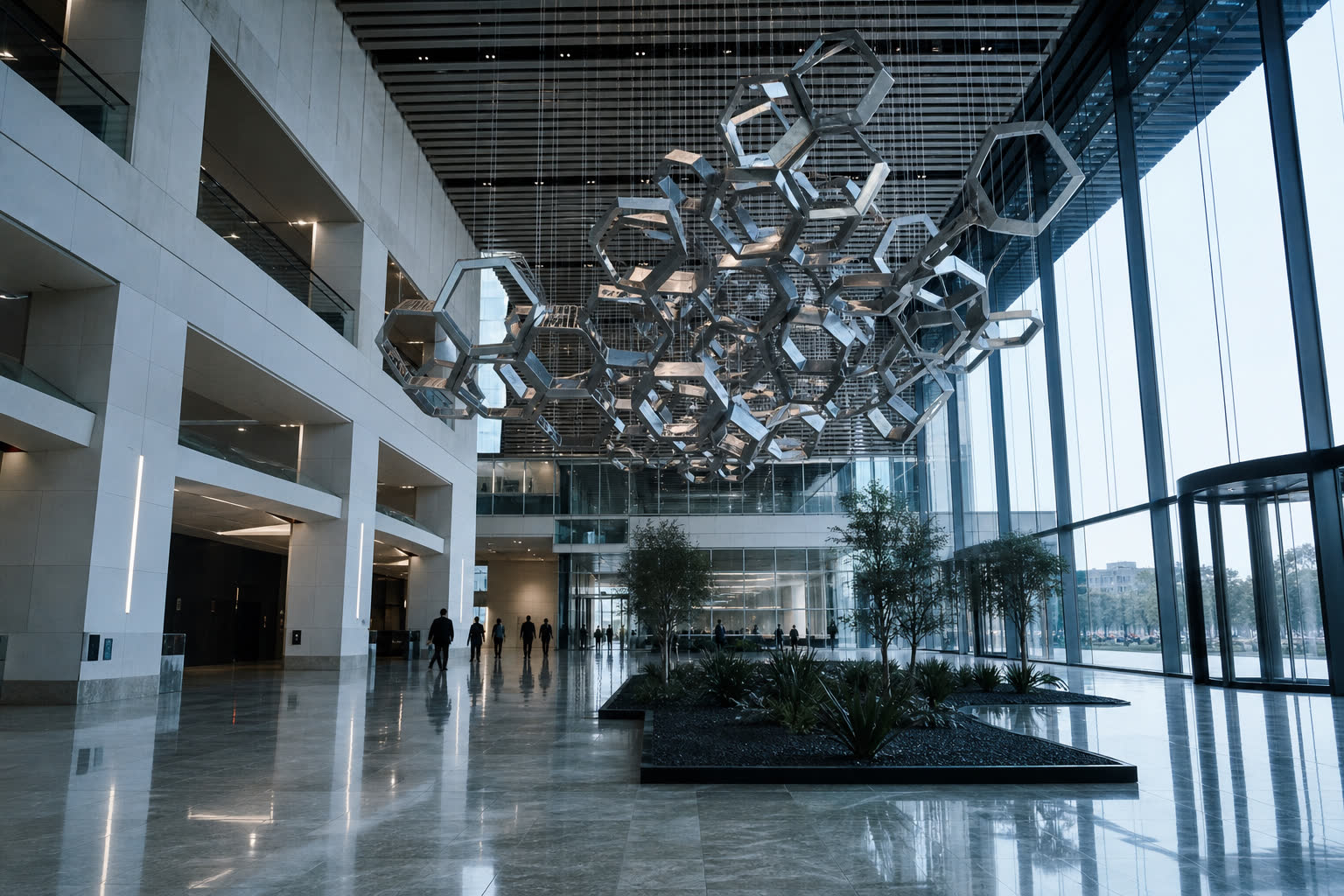 Atrium with a hexagonal kinetic sculpture suspended above a polished floor.